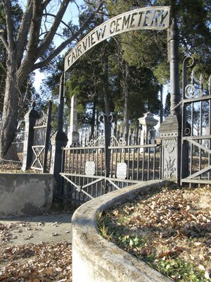 An ornate gate, above, marks an entrance to Van Buren’s historic Fairview Cemetery. In “Silent Storytellers,” premiering next week on AETN, graveyarder Abby Burnett discusses the folk art and burial practices of the Northwest Arkansas Ozarks. Closer observation of Mary Ollie Whitlow’s grave, left, in the Wesley Cemetery revealed a hidden compartment concealing her photograph. It was the perfect moment for a graveyarder like Burnett.