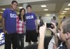 Phillip Freeman, right, takes a picture of Vinny Phahurat, second from left, with Rogers High cross country runners Martin Resendez, left, and Jeremiah Fleeman before a signing ceremony Friday at Rogers High School. Fleeman and Resendez signed with the University of Central Arkansas to run cross country.