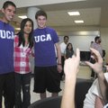 Phillip Freeman, right, takes a picture of Vinny Phahurat, second from left, with Rogers High cross ...