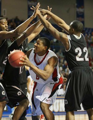 Arkansas State’s Jeremy Thomas finds himself surrounded by UALR defenders, including Solomon Bozeman (22) and Courtney Jackson (12), in the first half Saturday in Hot Springs.
