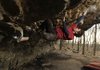 Cole Fennel demonstrates bouldering at a site in Northwest Arkansas on Feb. 19. The 24-year-old wrote a 400-page guidebook cataloging many rock climbing sites in the state.