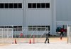 A security officer secures a gate at the new Toyota plant in Blue Springs, Miss. No cars have been produced there because of the slow economy.