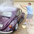 BEETLE BATH - John Burke washes his wife Ane Burke’s 1961 Volkswagen Beetle on Tuesday at their home...