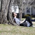 TREE OF KNOWLEDGE - Laura Finn, 18, enjoys the warm weather Tuesday on the lawn of Old Main at the U...