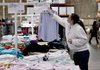 A Costco worker changes a price sign at a Mountain View, Calif., store last week. Firms trimmed wholesale inventories in January.