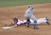    University of Arkansas baserunner Collin Kuhn dives into second base in front of the tag of South Dakota State second baseman Scott Hood in the second inning of Tuesday afternoons game against South Dakota State at Baum Stadium in Fayetteville.
