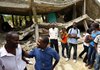  
School principal Jean Manesse, left, and priest Pere Desire Fritz, talk with their students at a high school in Sheridan, Haiti about the building collapsing in an earthquake which devastated the country 2 months ago. The school was the first of 44 build in rural Haiti by the Haitian Education Foundation which is based in El Dorado.