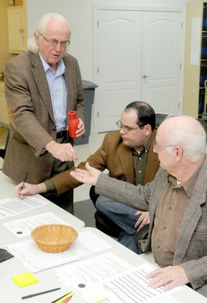 Benton County election commissioners Bill Williams, from left, Tim Hutchinson and E.J. Miller draw numbered dice Friday to determine the ballot order for 22 candidates at the Election Commission in Bentonville. The drawing was for contested races in the May 18 primary elections.