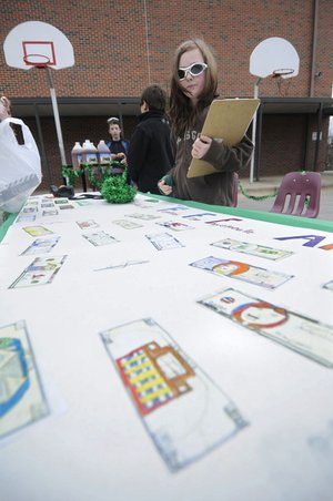 Kylee Aaron, 10, prepares for the arrival of the Fundred Sous Terre armored truck Friday that will take Fayetteville Fundred Dollar Bills — original, hand-drawn interpretations of $100 bills — from Leverett Elementary School to Washington D.C.