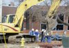 Construction workers and representatives with Arkansas Western Gas dig a hole Friday to shut off a natural gas line feeding into Springdale High School after an excavator clipped the two-inch line causing a leak. Part of the high school was evacuated as a precaution, but there were no reports of injuries.
