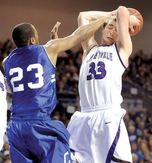 Fayetteville senior Adam Nobel, right, has the ball knocked from his hands by Conway senior Preston Purifoy during the second half of the Class 7A State Championship on Friday in Summit Arena in Hot Springs. Conway defeated Fayetteville 66-56.