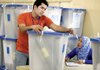 Election workers check the locks on ballot boxes at a counting center in Baghdad on Tuesday.