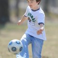Ryan McQuade, 12, of Houston kicks a soccer ball back to his father while enjoying the warm weather ...