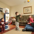 Stephanie Mertz, left, holds their 1-year-old son, Samuel, as her husband, James, right, plays with ...