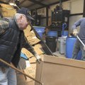 CARDBOARD CONVEYOR - Jay Louviere, left, and Kyle Kallstrom load cardboard onto a conveyor belt Wedn...