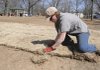 GRASS ROOTS - Meagan Lipscomb, a horticulturist with the Bentonville Parks and Recreation Department, lays sod Thursday at Gilmore Park in Bentonville.
