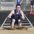Rogers High’s Chase Graham lands in the sand during the triple jump competition Thursday at the Tige...