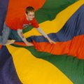 Logan Walz of Springdale takes his turn playing the cat in a cat-and-mouse parachute game at the Jon...
