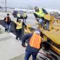 BACK ON THE STREETS - A crew with the Springdale Street Department pave a section of the road Tuesda...