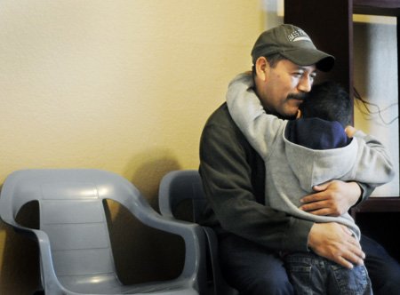 
                               
                                  Photo by Sarah Bentham&mdash;
                               
                           
                           Miguel Hernandez hugs son Rudy on Wednesday at the apartment the family is renting in Springdale.