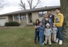 Miguel and Maricela Hernandez, center, stand outside their house in Springdale with their children, from left to right, daughters Brisa, Roselyn, twins Aaron and Rudy and oldest son Angel. The family fought for more than a year to save the home from foreclosure.