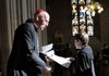 Primate of All Ireland Cardinal Sean Brady on Saturday hands a letter from Pope Benedict XVI to a child at St. Patrick’s Cathedral in Armagh, Northern Ireland.