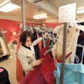 PROM PREP - Volunteer Jill Hollis of Fayetteville sorts through a rack of prom dresses while looking...