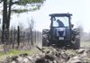 Chuck Harris with the Springdale Public Works Department tills a plot of land Friday on McCollough Drive that will be used for a community garden in Springdale.