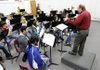 Russell Robinson, band director at Springdale High School, conducts the band as they get a first look at some music Wednesday at the school. The marching band, which all the members of this band are a part of, is trying to raise money to participate in a parade this summer in Washington D.C.