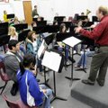 Russell Robinson, band director at Springdale High School, conducts the band as they get a first loo...