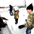 Blake Collins, 9, right, and his 6-year-old brother, Zach, center, work with their father, Korey Col...