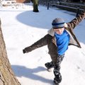 Cody Brown, 7, plays on snow that is already beginning to melt Monday in front of the Bentonville Pu...