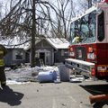 Cpt. Nolan Jones, with the Lowell Fire Department, looks at damage Monday caused by a fire at a hous...
