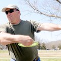 Darren Hill lets fly with a long drive Tuesday through a tree-choked section of the disc golf course...