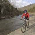 Tim Scott, assistant park superintendent, pedals his mountain bike along Lee Creek at Devil’s Den St...
