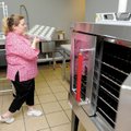 Stephanie Garst, owner of Kupcakes and More in downtown Bentonville, moves baking sheets around in h...