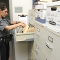 Deputy Shannon Bailey with the Benton County Sheriff’s Office looks through a file cabinet for a wri...