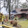 Firefighters survey damage to a home at 15562 Lakecrest Drive in the Hickory Creek community on Thur...