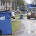 A driver with Allied Waste picks up a recycling container Thursday in Bentonville.