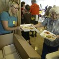 Roseanna Falk, right, hands Gracie Terrell a couple of take-out meals on April 15, 2006, prepared fo...