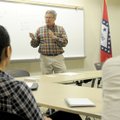 Octavio Sanchez teaches Spanish phrases Saturday to a small group at Bentonville Public Library.