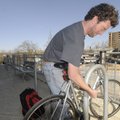 Danial Estes of Fayetteville locks his bicycle Friday at the Fayetteville Public Library. Estes says...