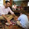 Chad Sullivan plays with his son Noah as his wife, Jenna, holds their daughter Campbell in the backg...