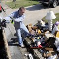 Tony Pennington cleans up a pile of garbage outside a home Friday off Evelyn Street in Springdale. P...