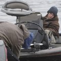 Nathan Wilson, of Springdale drives his boat onto a trailer Sunday after fishing at Swepco Lake near...