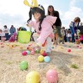 Brianna Cruz, 3, of Springdale reaches for a candy-filled egg as her mother, Maritza Cruz, right, ur...