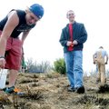 Baine Farmer, left, and Hunter Mobley, both with Rogers High School DECA Club, plant shrubs Sunday o...
