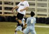 Bentonville junior Nathan Bracy, top, heads the ball over Springdale Har-Ber’s Maricio Salas in the first half Tuesday in Springdale.