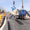 A crew moves concrete barriers Tuesday to shift traffic to two newly paved lanes on East Central Ave...
