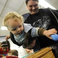 EGG HUNT - Johnathon Hollon, 18 months, of Westville, Okla., pulls plastic eggs out of the pocket of...